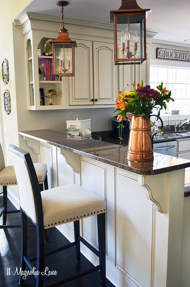 Creamy off-white kitchen with copper accents, brown and black granite | 11 Magnolia Lane