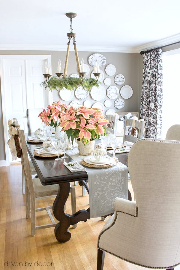 dining-room-decorated-for-christmas-with-pink-poinsettias-and-gold-and-silver-ornaments-and-trees