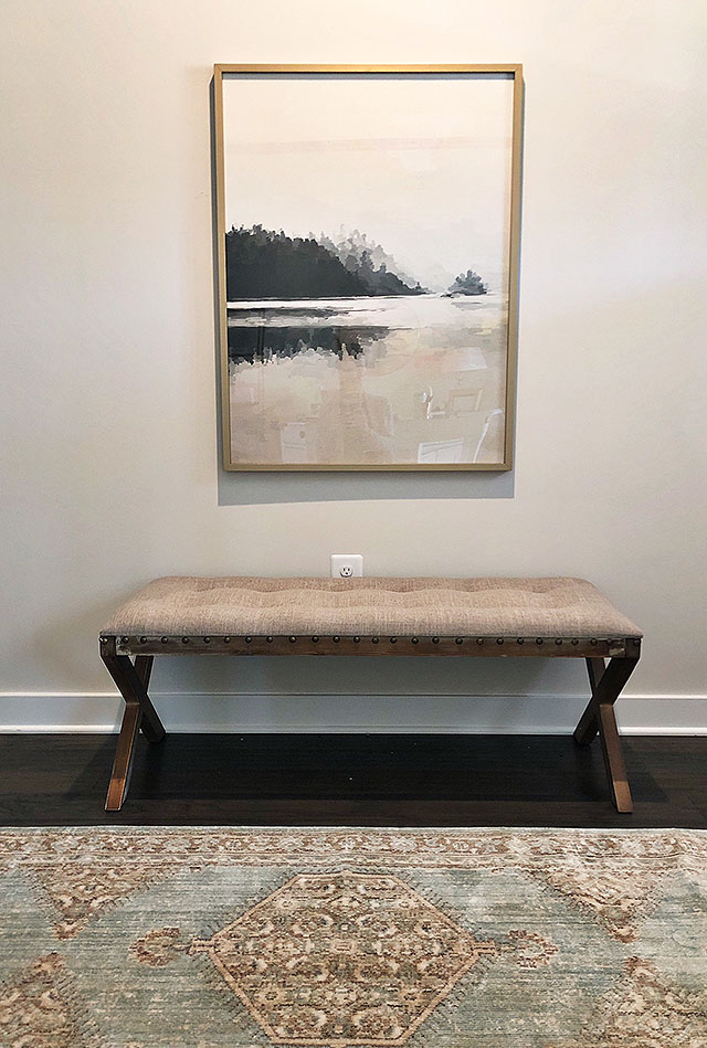 An affordable bench and art decorate a long hallway