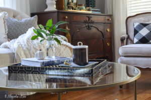 Living room with black and white striped chairs, round gold coffee table, and vintage touches | 11 Magnolia Lane