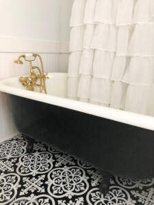 Vintage bathroom redo with black and white clawfoot tub and brass fixtures | 11 Magnolia Lane